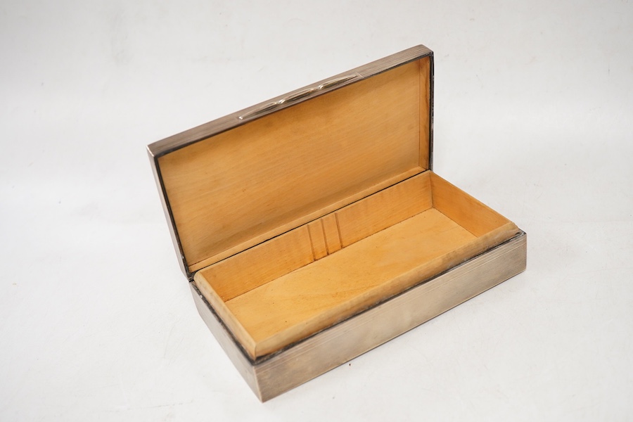 A George VI engine turned silver mounted rectangular cigarette box, by A. Wilcox, Birmingham, 1938, 17cm, with engraved inscription.